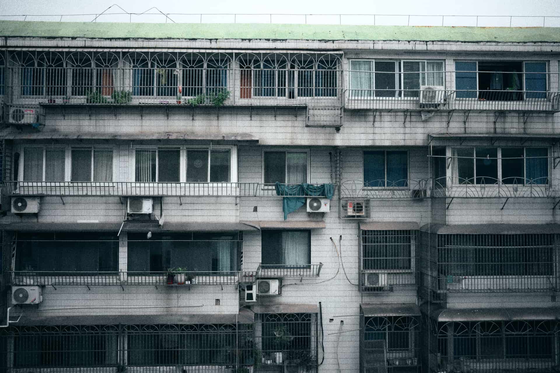 A window air conditioner installed in the lower sash of an apartment window, seen from inside the room